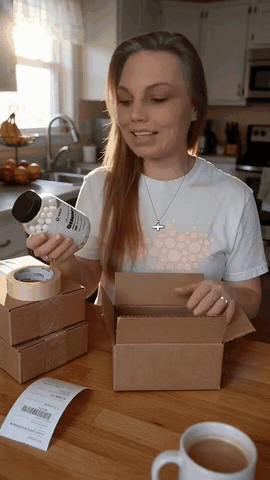A Klovera video made for an eBay listing: a woman unboxes an omega-3 bottle at her kitchen table